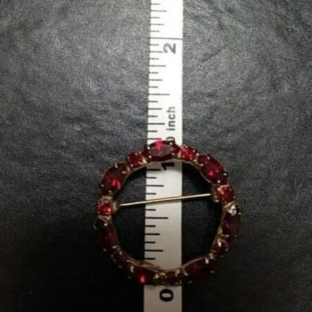 Vintage gold tone round pin w red rhinestones